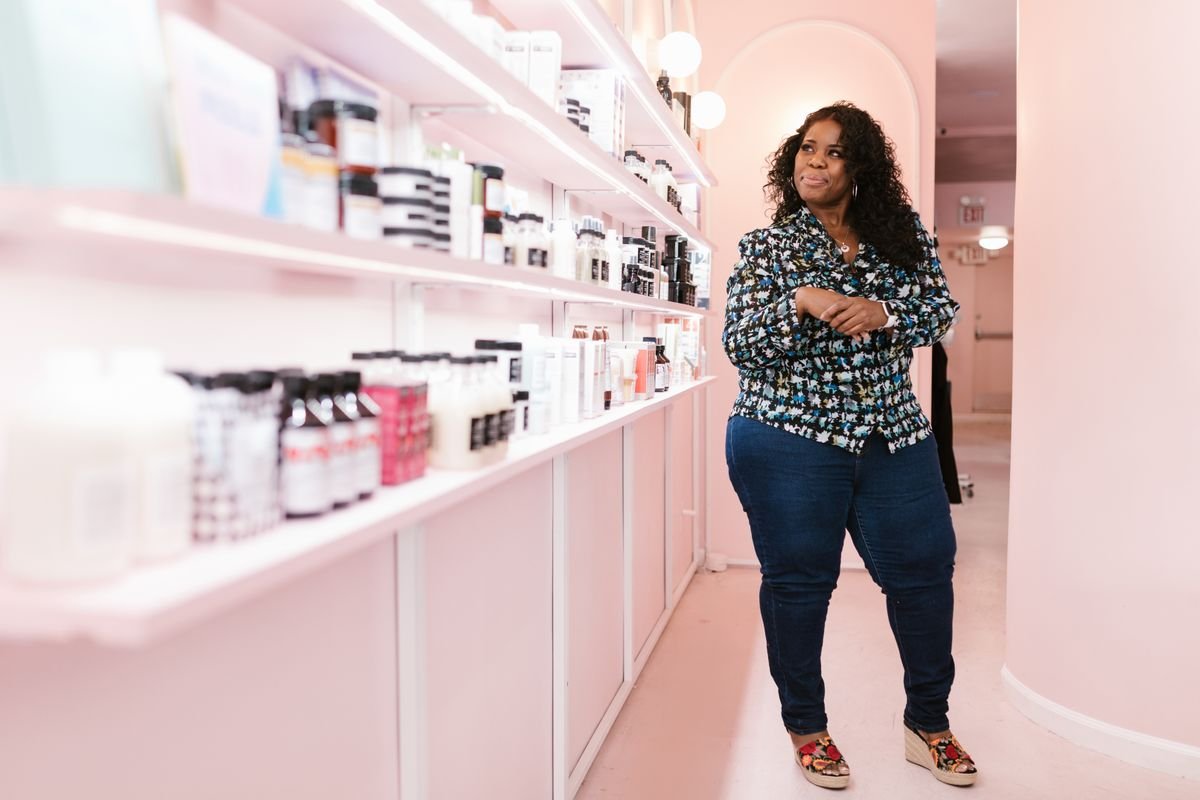 Woman considering products on shelves in a beauty shop