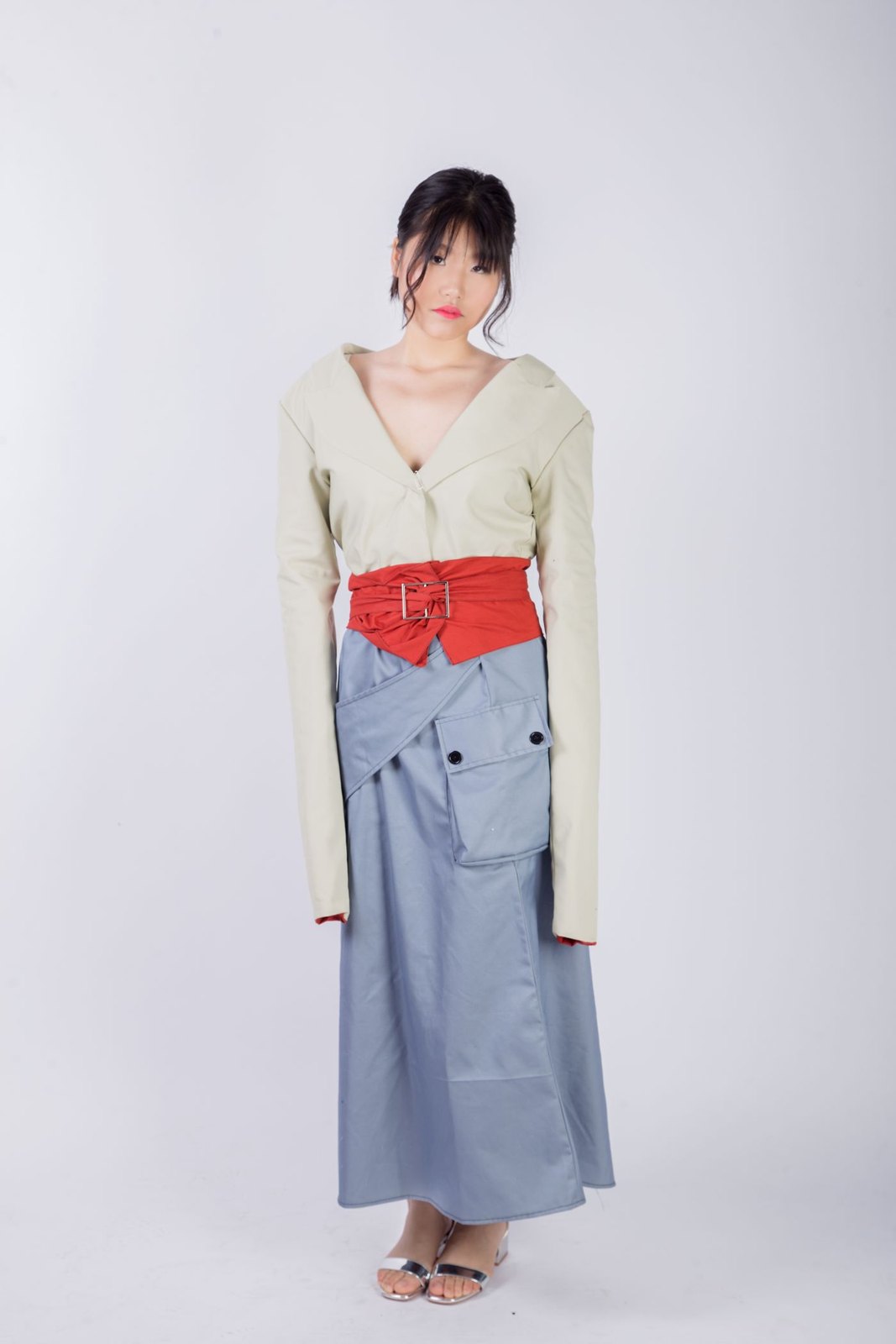 Red belt worn over a loose neutral outfit