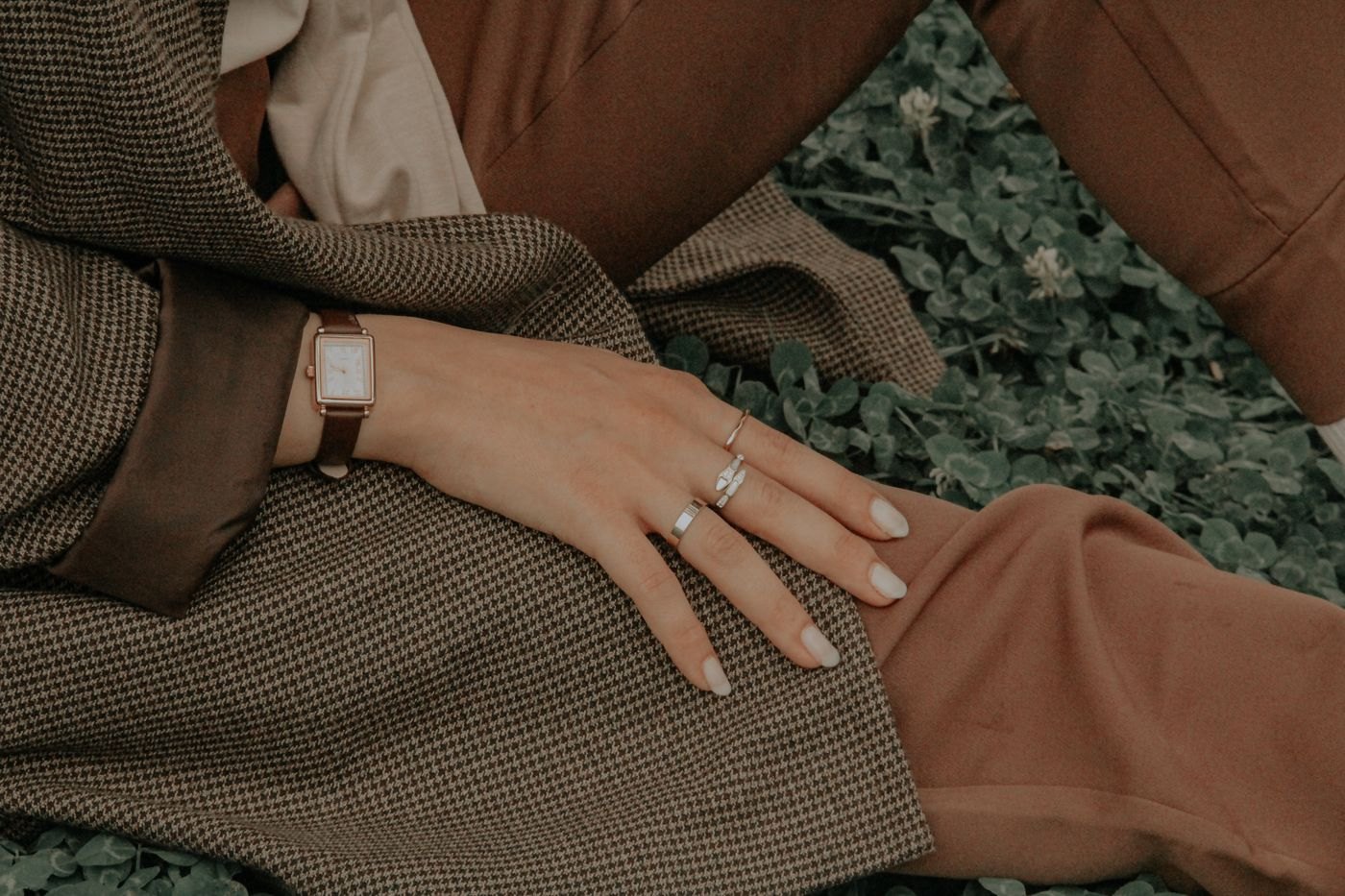 Jewellery beside the cuff of a checked sleeve