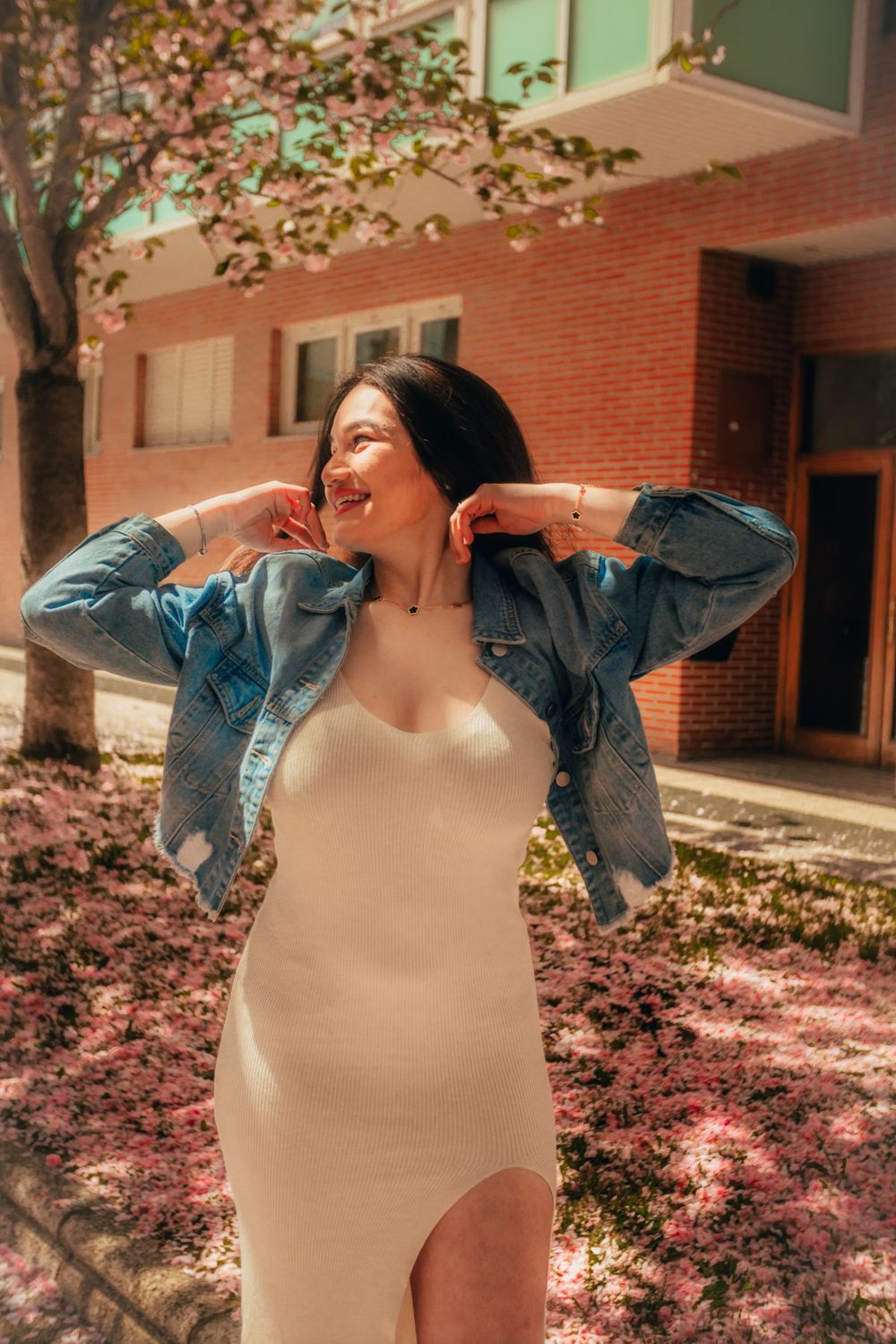 Denim jacket layered over a white dress