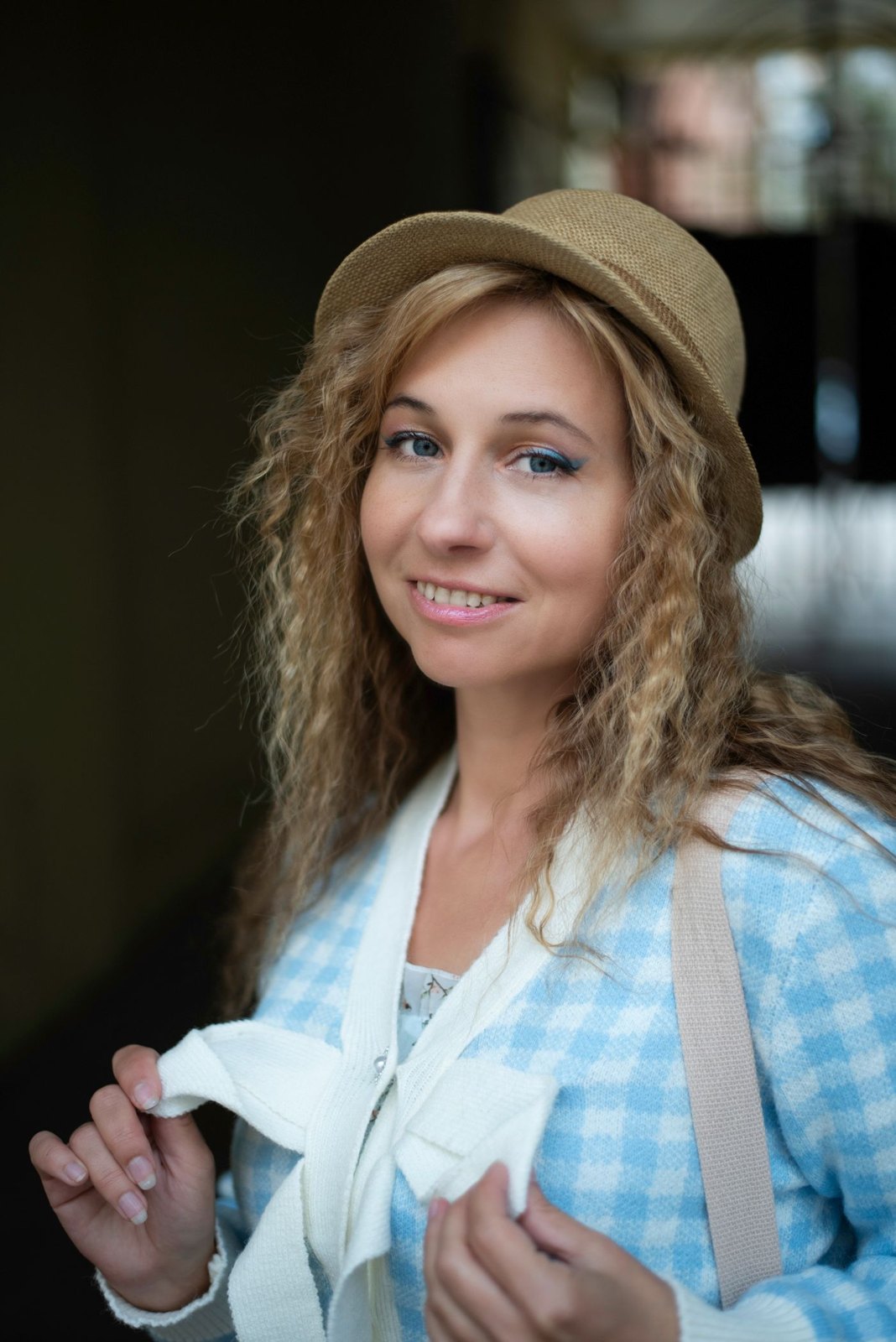Woman wearing a brimmed hat over curly hair