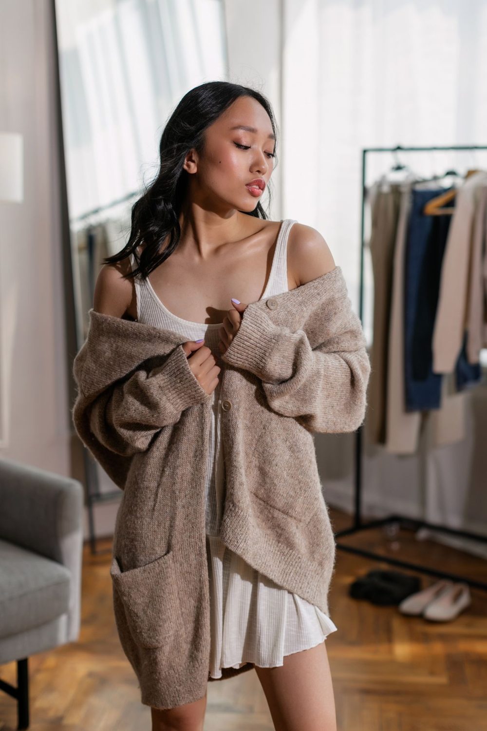 Brown knitted cardigan layered over a white dress