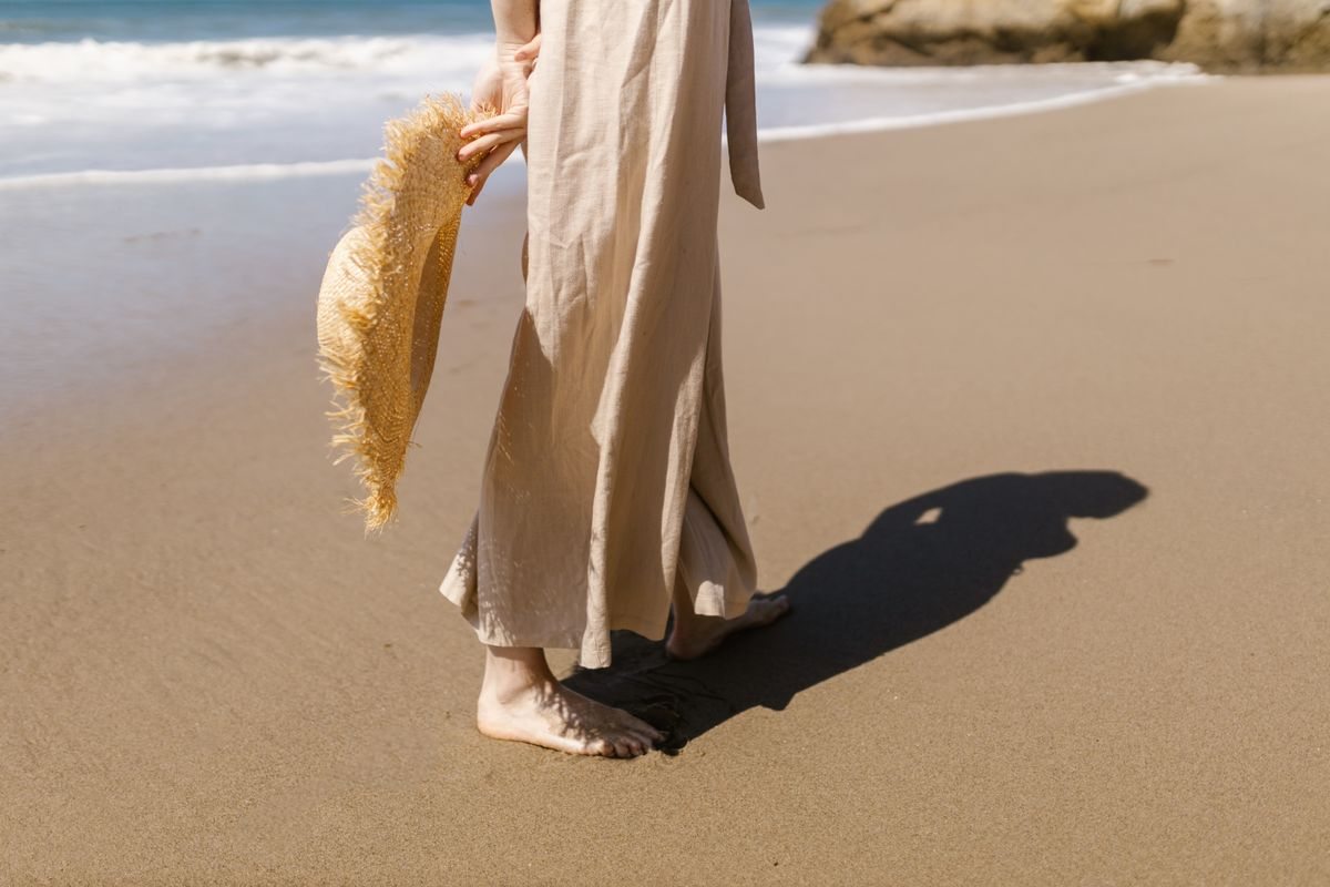 Beige linen trousers worn on a sandy beach