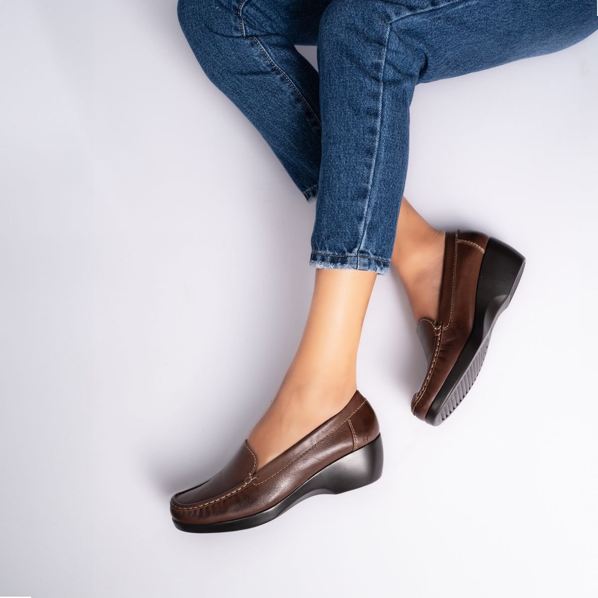 Brown leather loafers worn with blue jeans