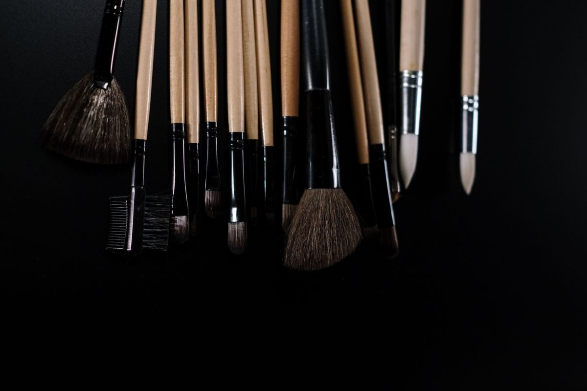 Makeup brushes with differently shaped heads on a dark surface