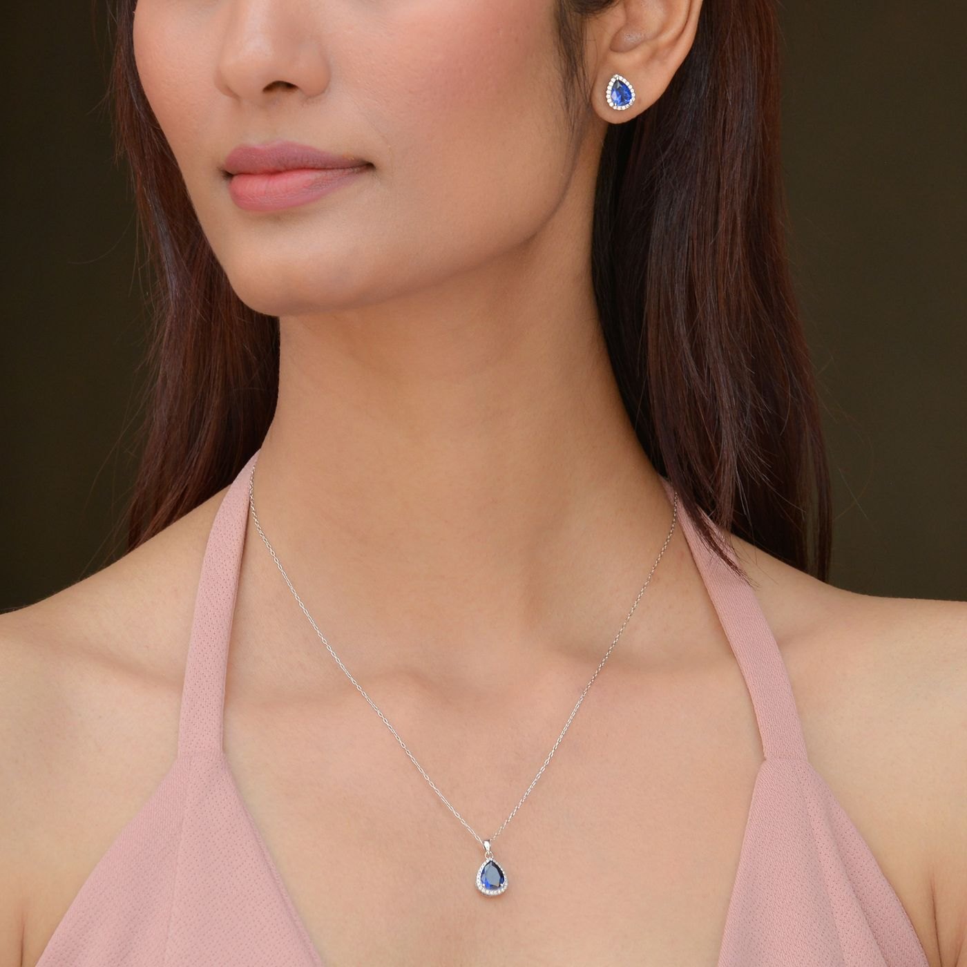 Blue pendant necklace resting below the collarbone