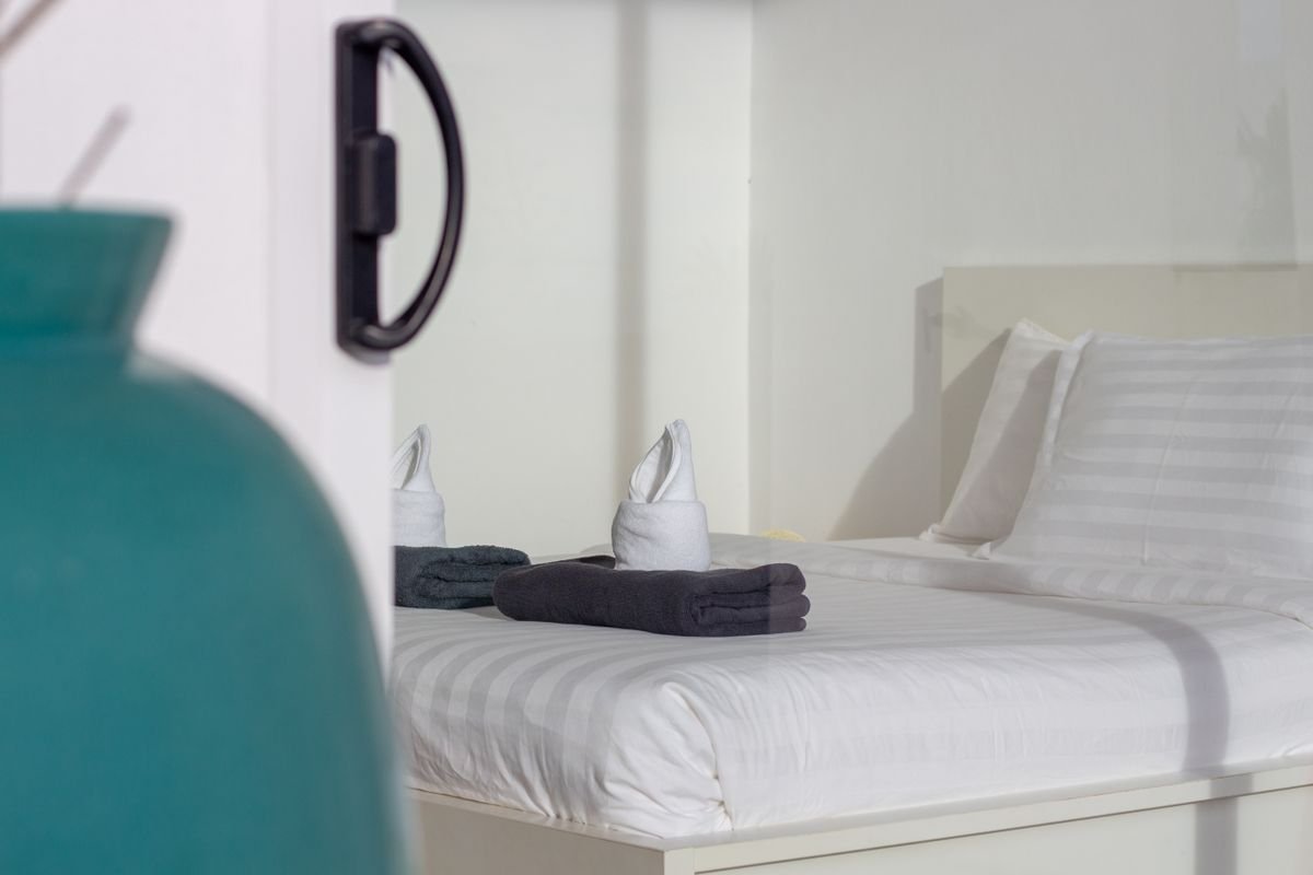 Folded towels placed on a freshly made bed
