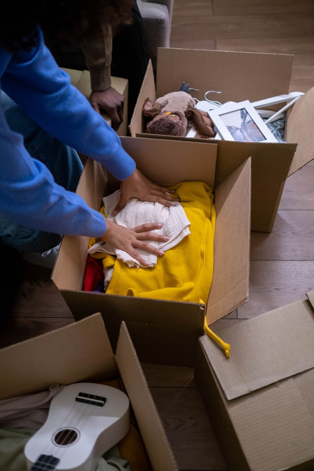 Hands placing clothing in a storage box