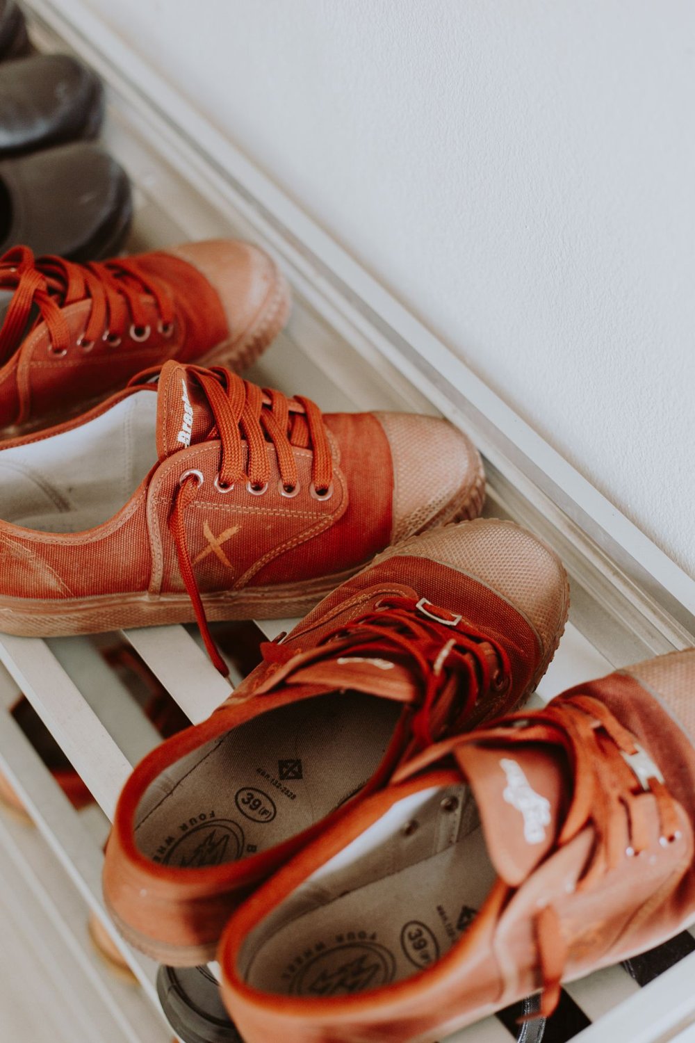 Rust-coloured shoes arranged on a white shoe rack