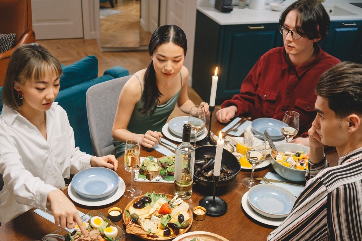 Friends sharing food at a candlelit table indoors