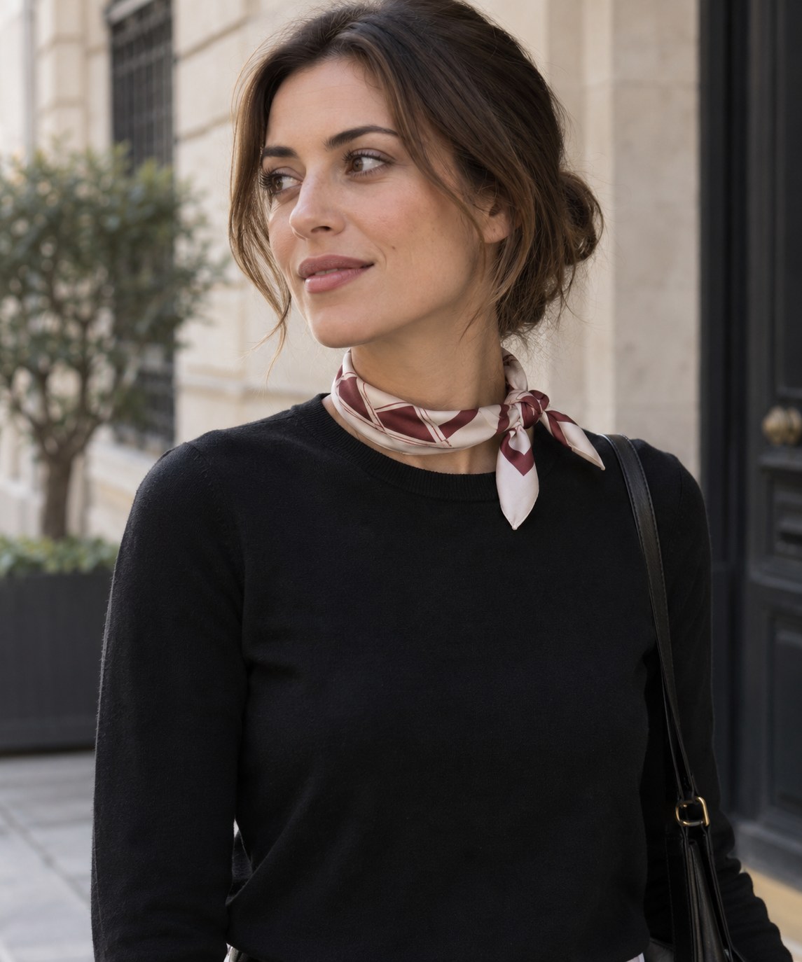 Small patterned scarf tied in a compact knot at the neck