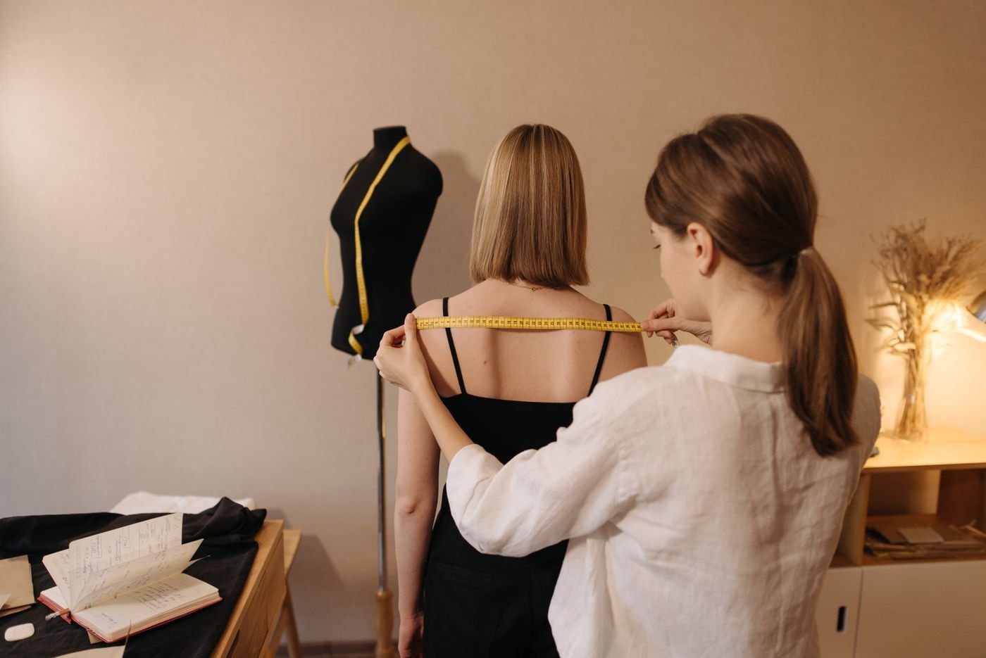 Tailor measuring a garment on a client