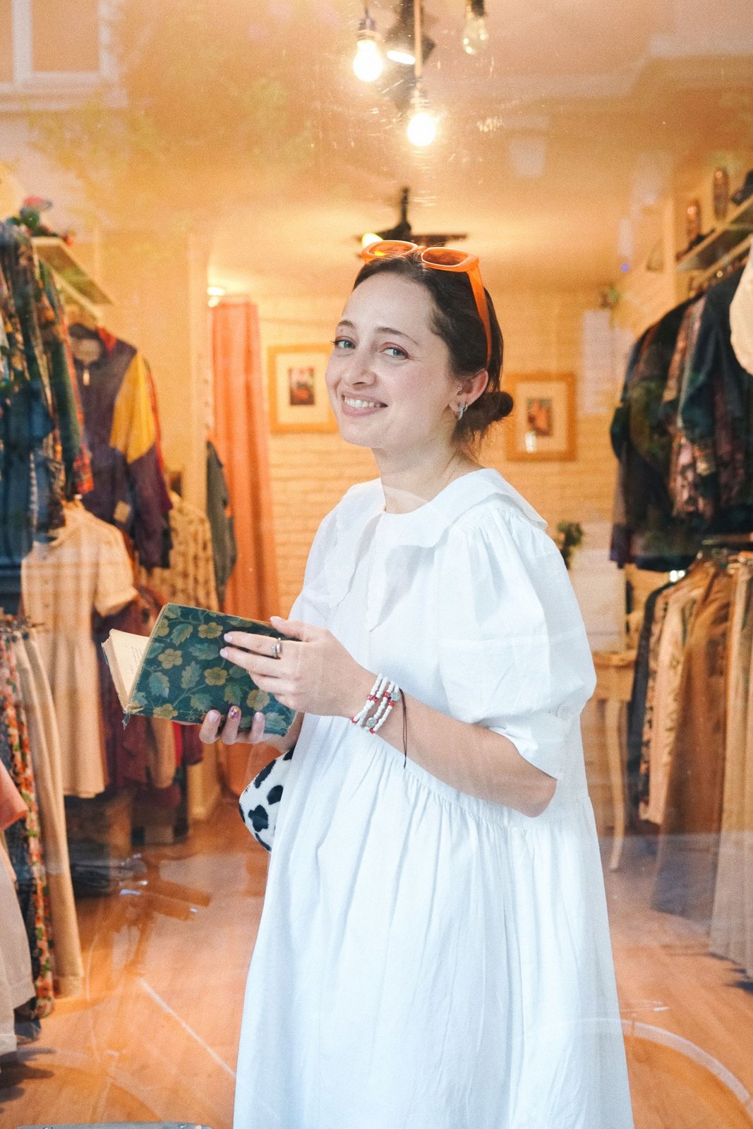 Woman holding a notebook among clothes