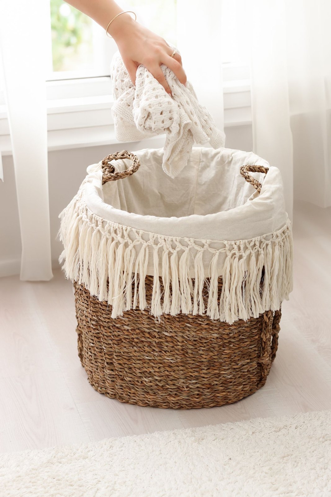 Hand sorting pale laundry into a wicker basket