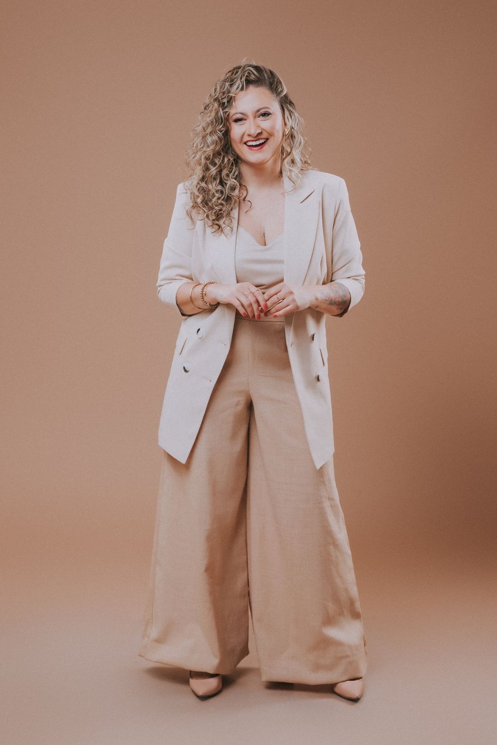 Woman wearing a beige longline blazer with wide-leg trousers