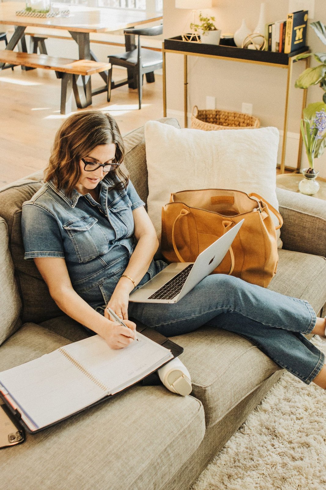 Leather work tote beside a woman using a laptop